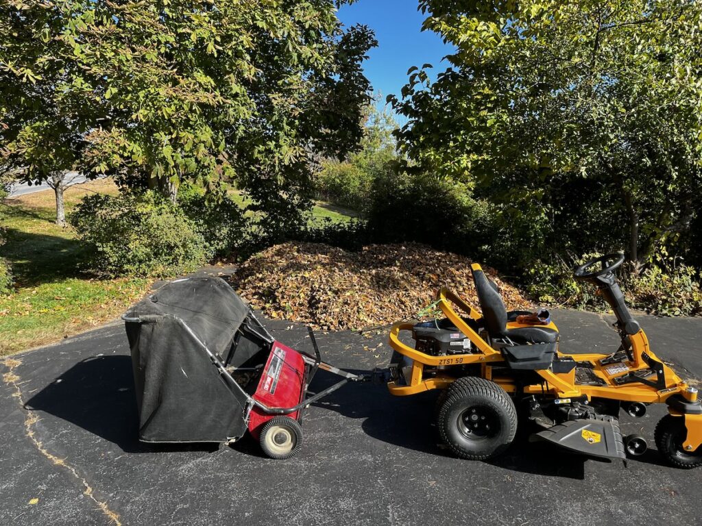 Pile of leaves staged in the driveway behind the collector/mower