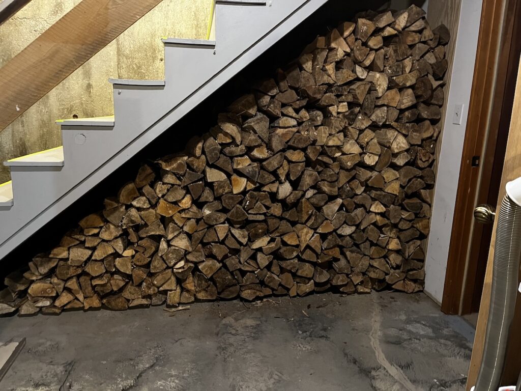 2/3 of a cord of hardwood firewood, re-split for our Jotul stove, moved into the basement and stacked under the basement stairs.